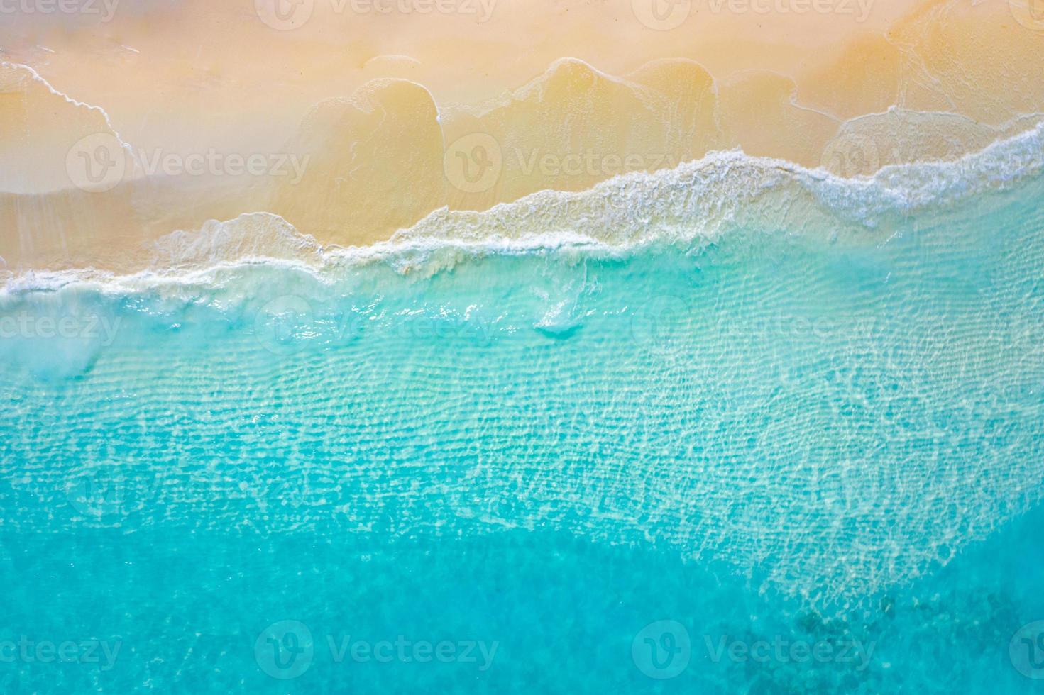 estate mare belle onde, acqua di mare blu in una giornata di sole. vista dall'alto dal drone. vista aerea del mare, incredibile sfondo di natura tropicale. bellissimo mare luminoso con spruzzi di onde e concetto di spiaggia di sabbia foto