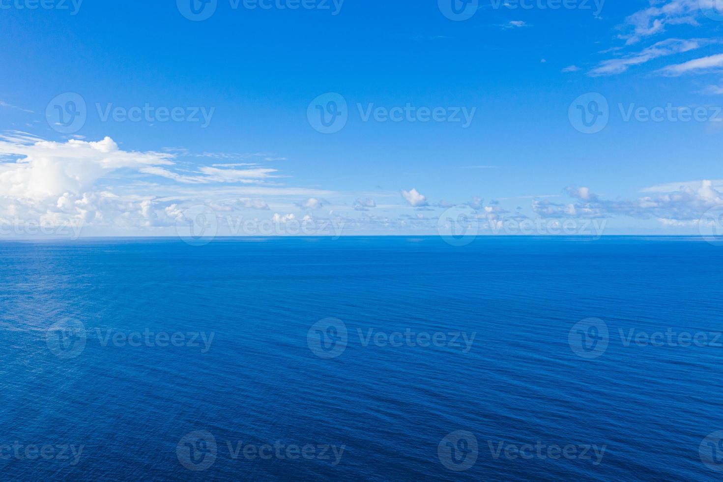 ampio panorama aereo dell'oceano blu profondo. rilassante paesaggio marino minimalista con piccole nuvole soffici. vista panoramica del drone della natura idilliaca. orizzonte marino infinito, vista tranquilla foto