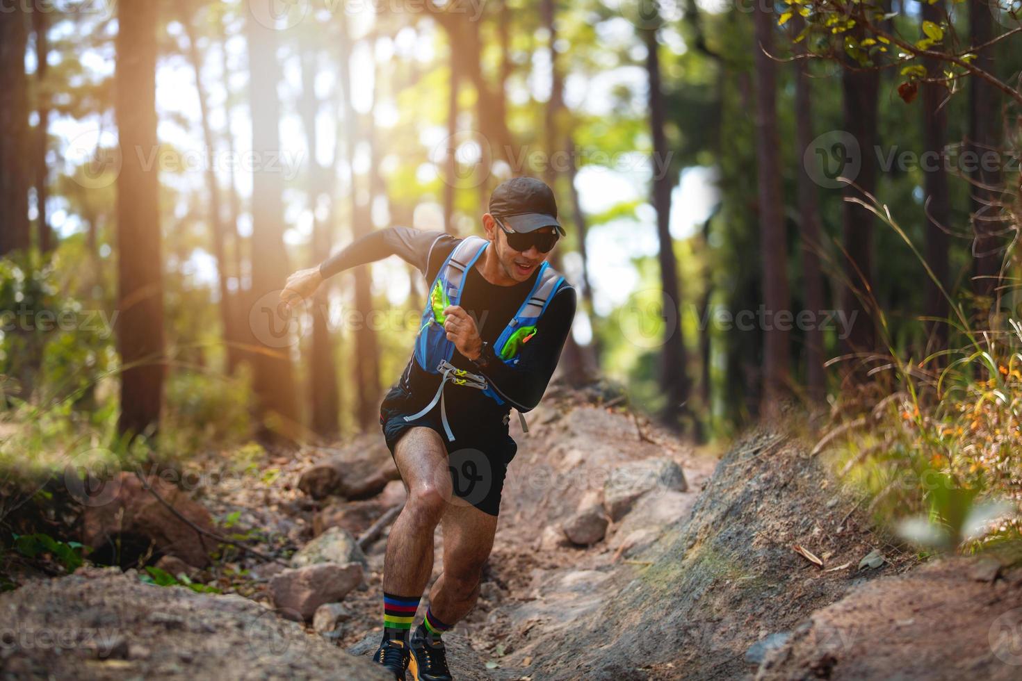un uomo corridore di sentiero. e piedi d'atleta che indossano scarpe sportive per il trail running nella foresta foto