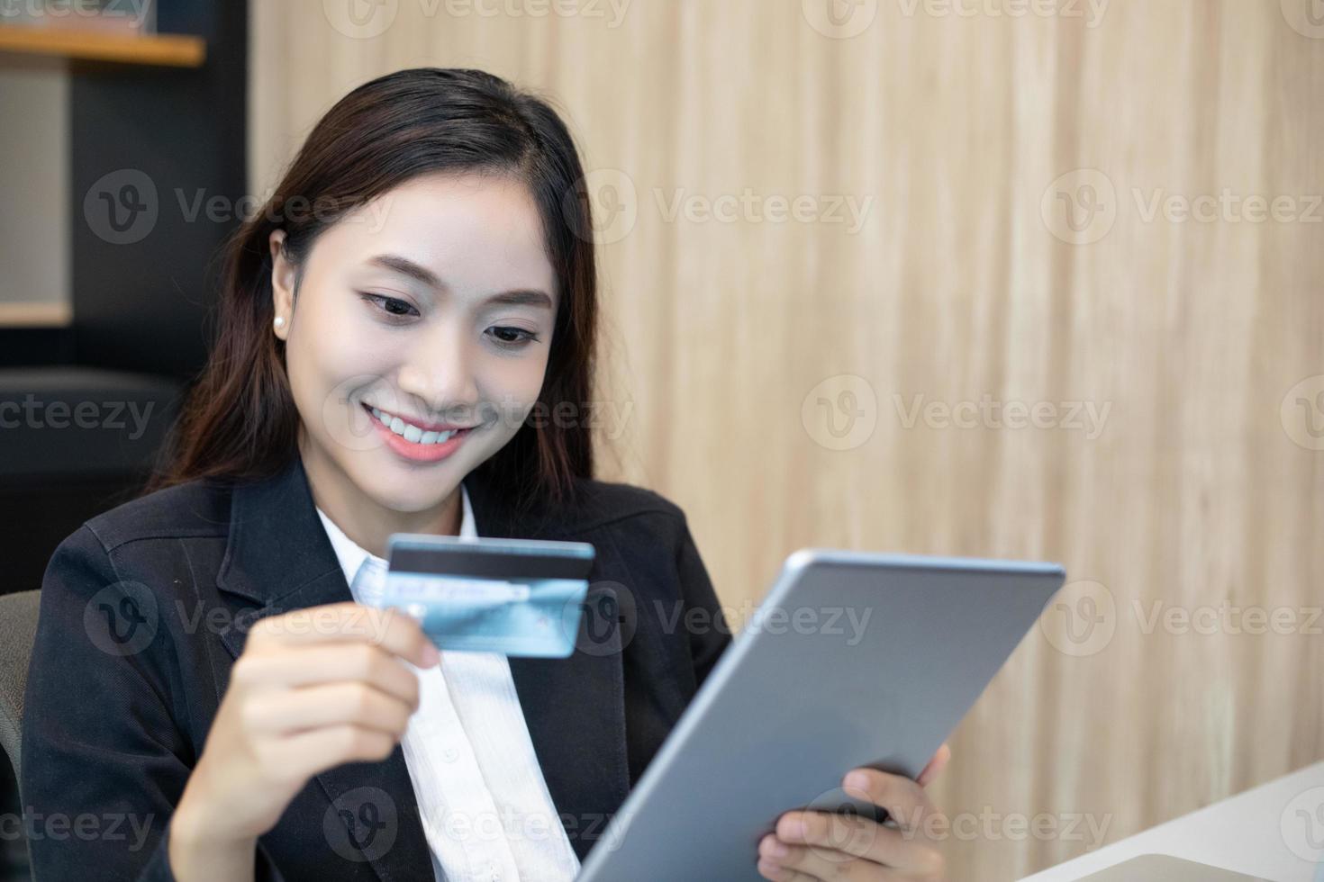 donna d'affari asiatica utilizzando tablet e carta di credito shopping online foto