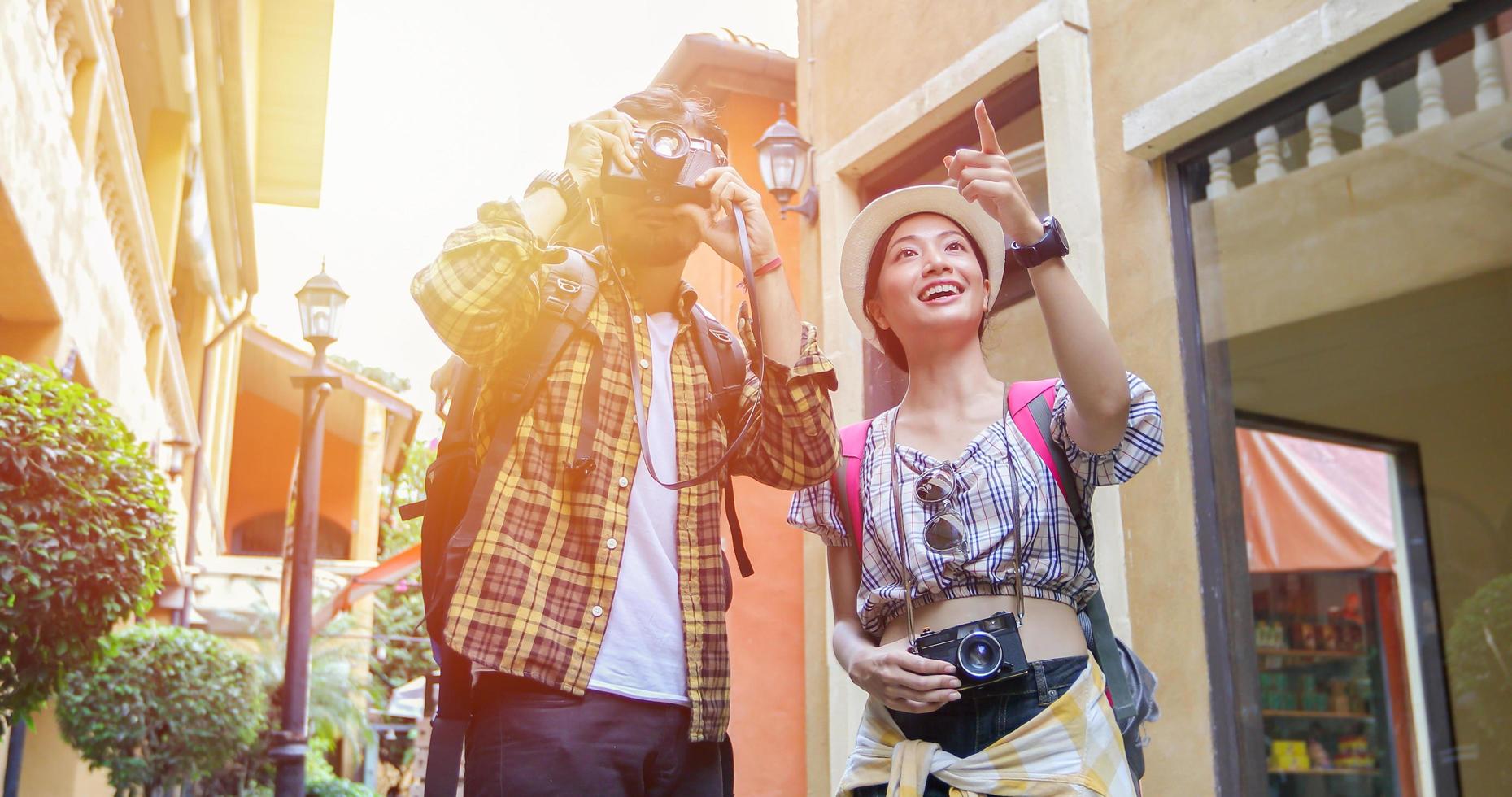 gruppo asiatico di giovani con amici zaini che camminano insieme e amici felici stanno scattando foto e selfie, tempo di relax in vacanza concetto di viaggio