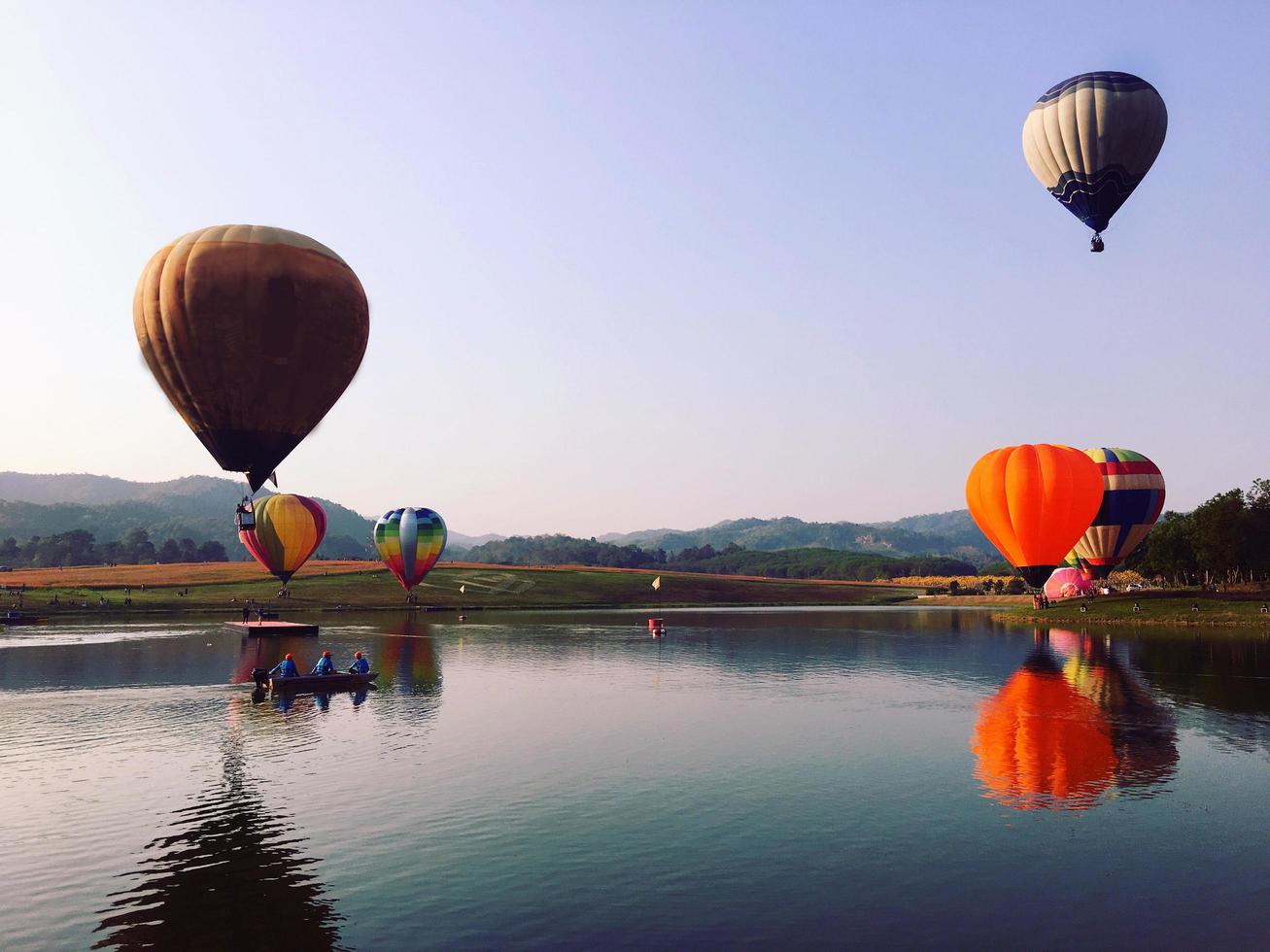 mongolfiere colorate che volano sopra il fiume foto