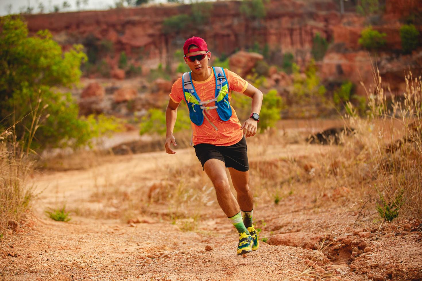 un uomo corridore di sentiero. e piedi d'atleta che indossano scarpe sportive per il trail running in montagna foto