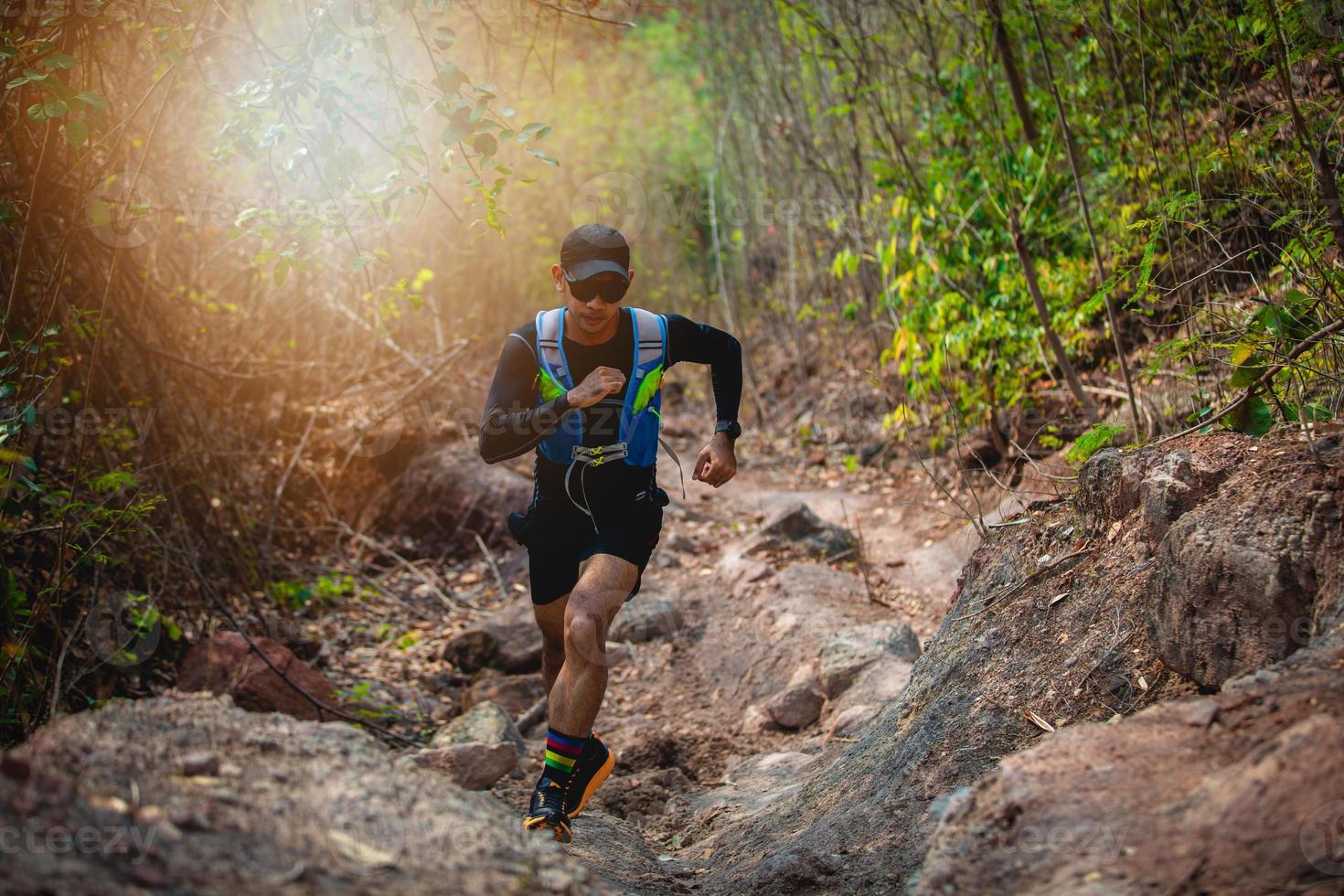 un uomo corridore di sentiero. e piedi d'atleta che indossano scarpe sportive per il trail running nella foresta foto