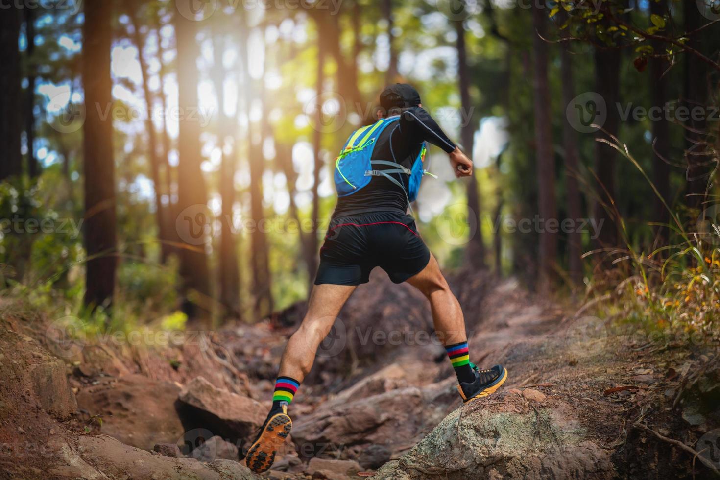 un uomo corridore di sentiero. e piedi d'atleta che indossano scarpe sportive per il trail running nella foresta foto