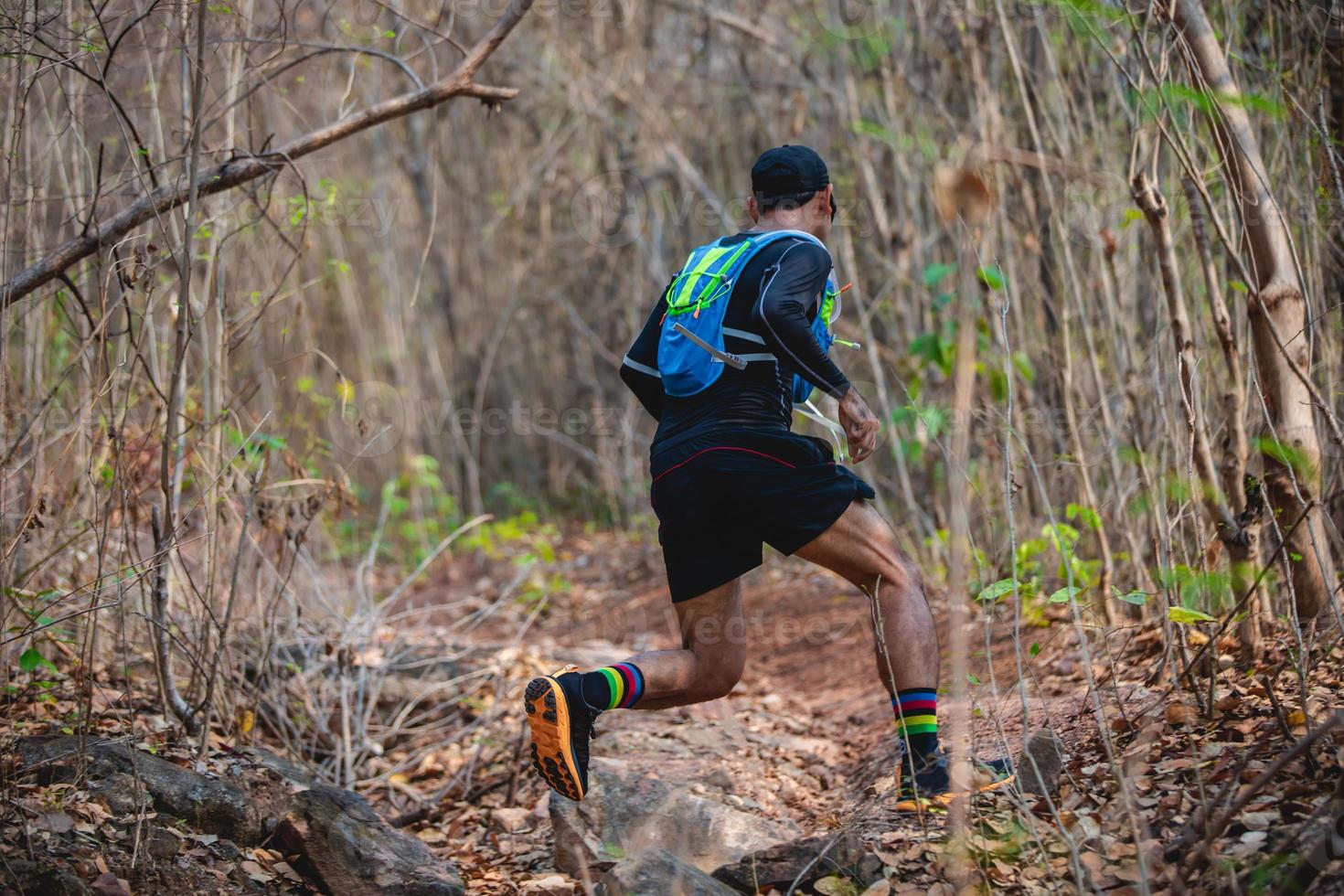 un uomo corridore di sentiero. e piedi d'atleta che indossano scarpe sportive per il trail running nella foresta foto