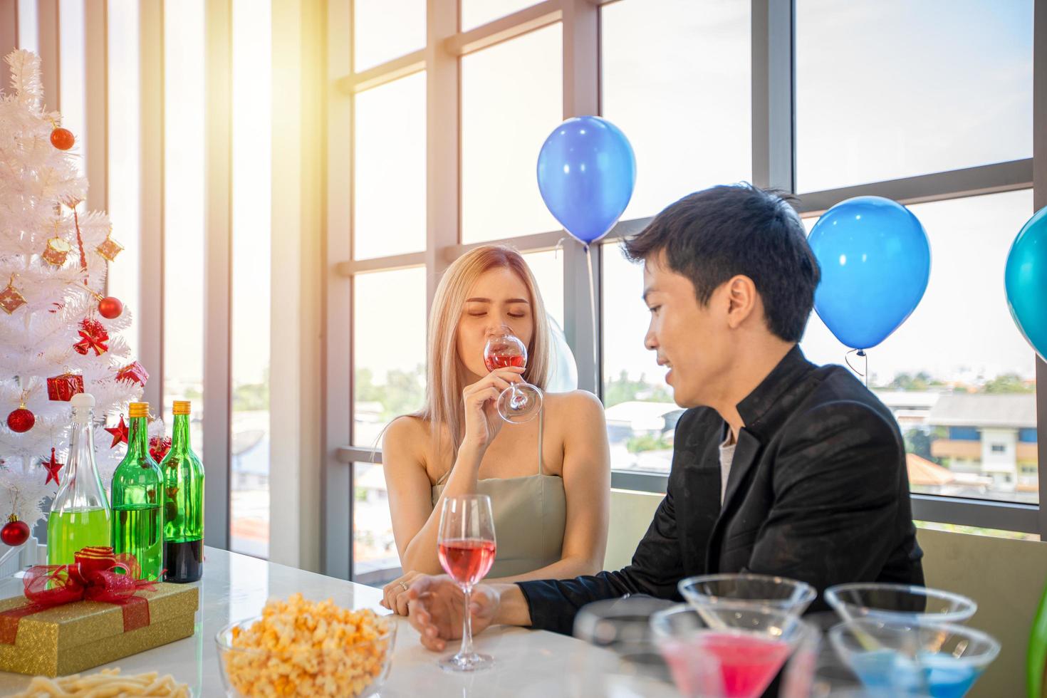 amante delle coppie asiatiche che fa festa con bevande alcoliche e giovani che si divertono in un bar a brindare cocktail con regalo di natale durante le vacanze di Natale e felice anno nuovo patty foto