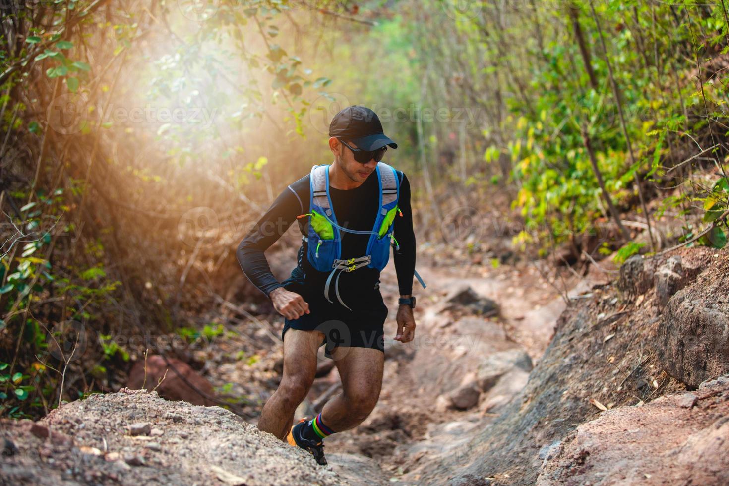 un uomo corridore di sentiero. e piedi d'atleta che indossano scarpe sportive per il trail running nella foresta foto