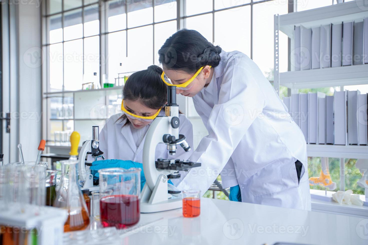 la ricerca medica e gli scienziati stanno lavorando con un microscopio e un tablet e provette, micropipette e risultati di analisi in un laboratorio. foto