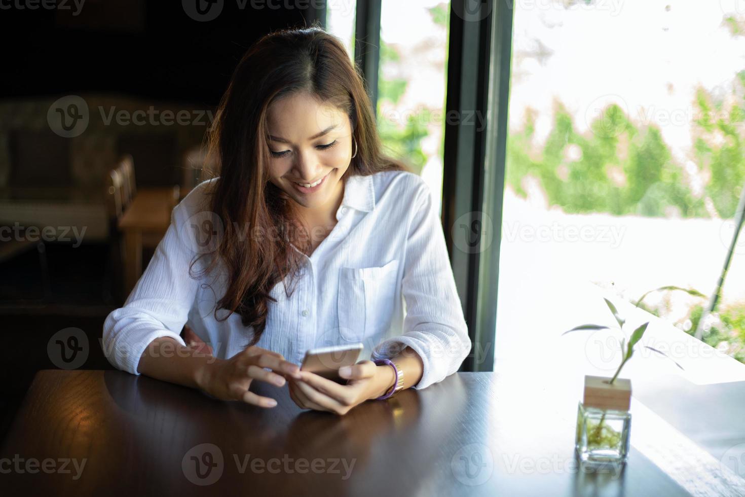 uomini e donne d'affari asiatici utilizzano smartphone mobili e touch per la comunicazione e il controllo degli uomini d'affari in ufficio foto