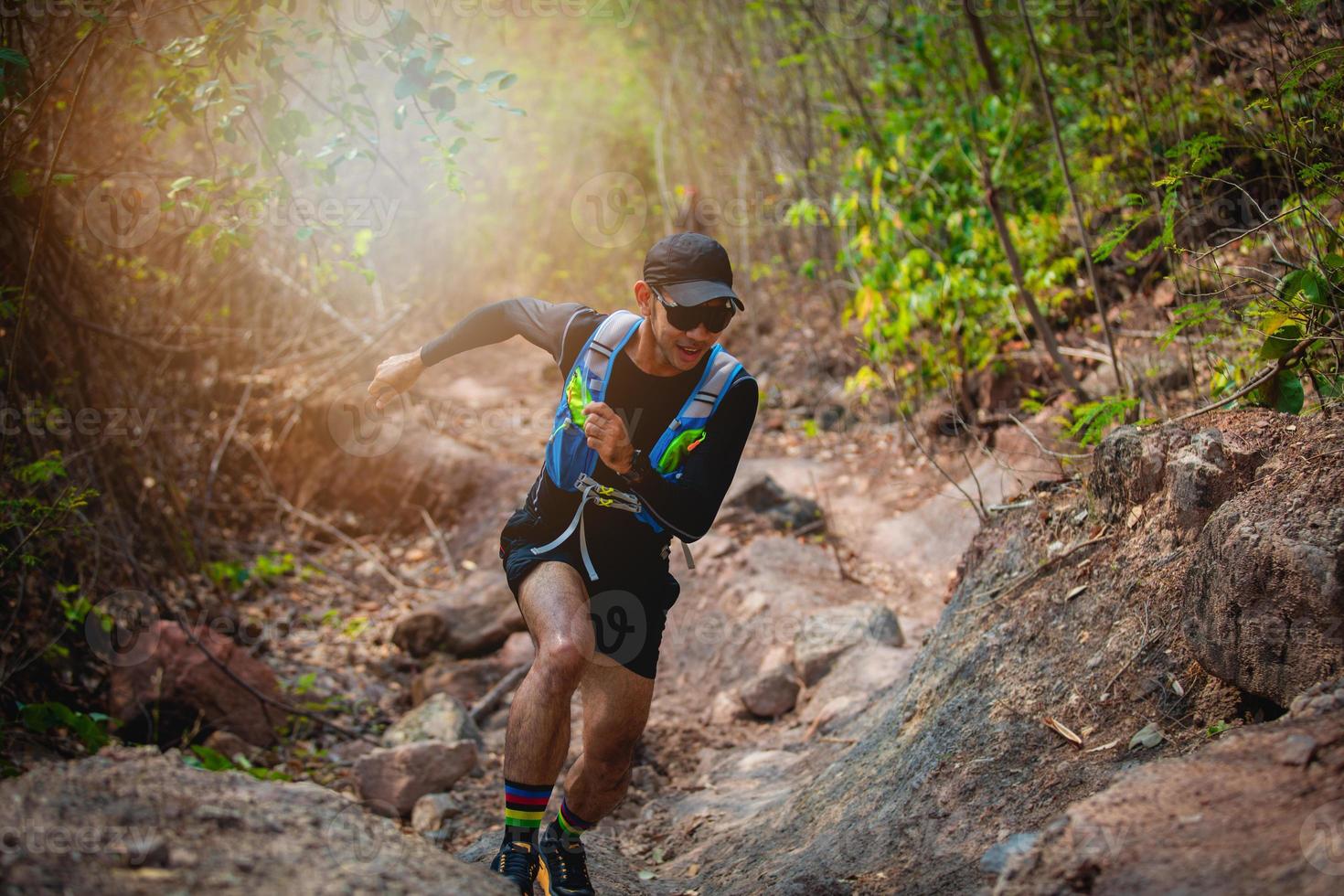 un uomo corridore di sentiero. e piedi d'atleta che indossano scarpe sportive per il trail running nella foresta foto