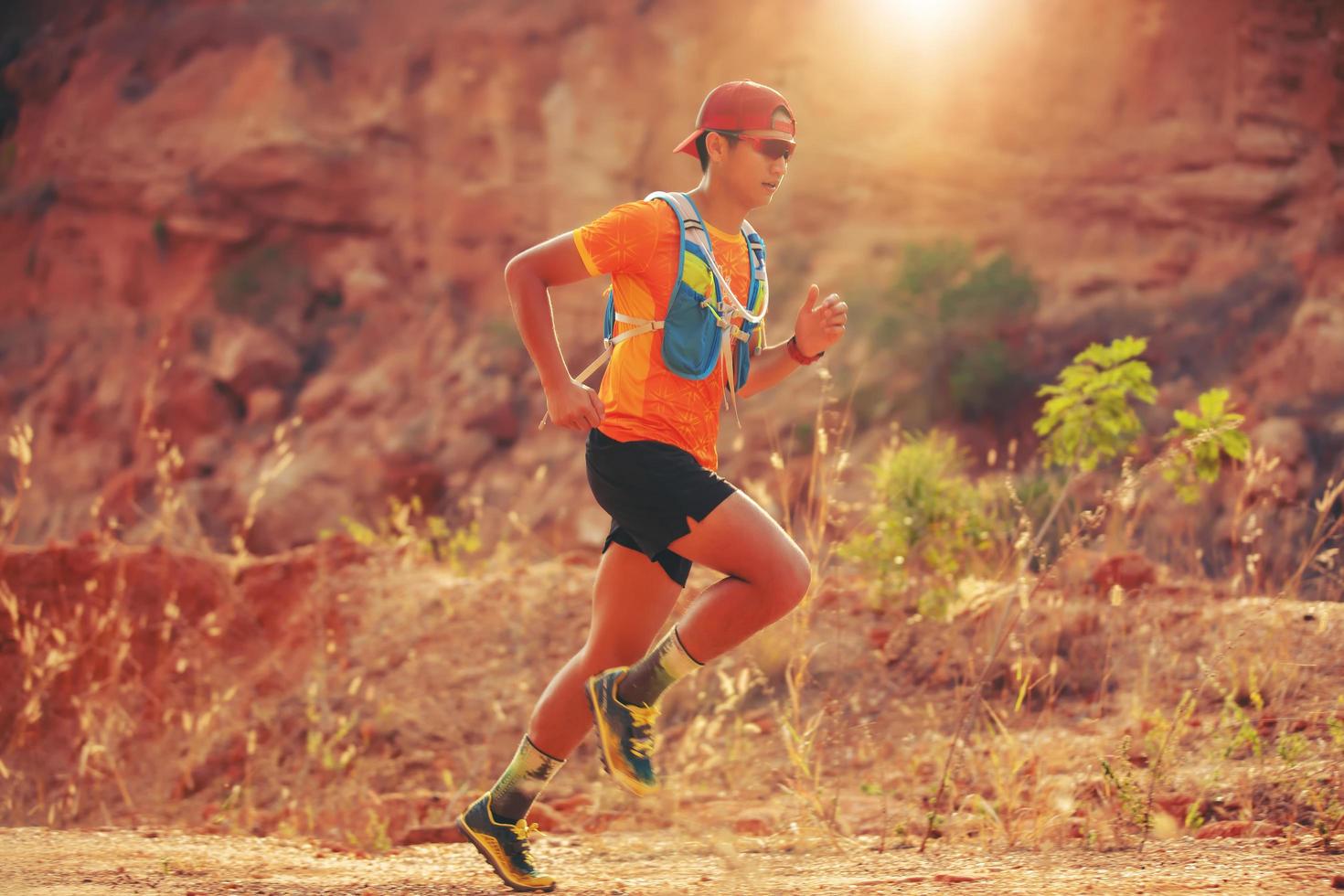 un uomo corridore di sentiero. e piedi d'atleta che indossano scarpe sportive per il trail running in montagna foto