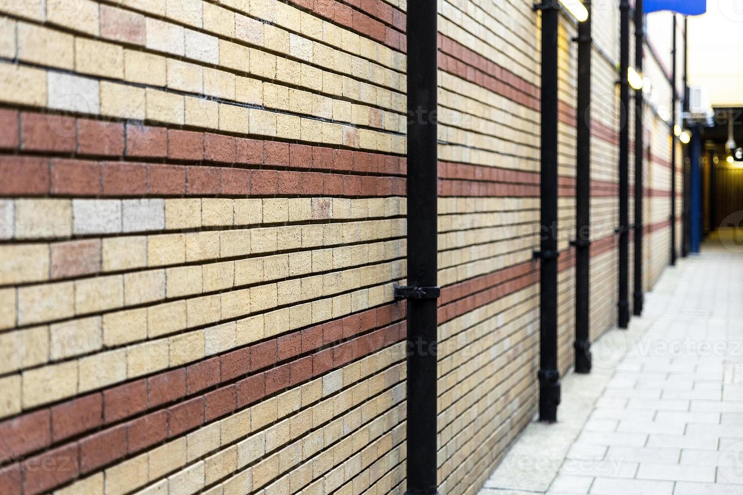 muro di mattoni dipinto di rosso e beige per lo sfondo. guarda in profondità. messa a fuoco selettiva. foto