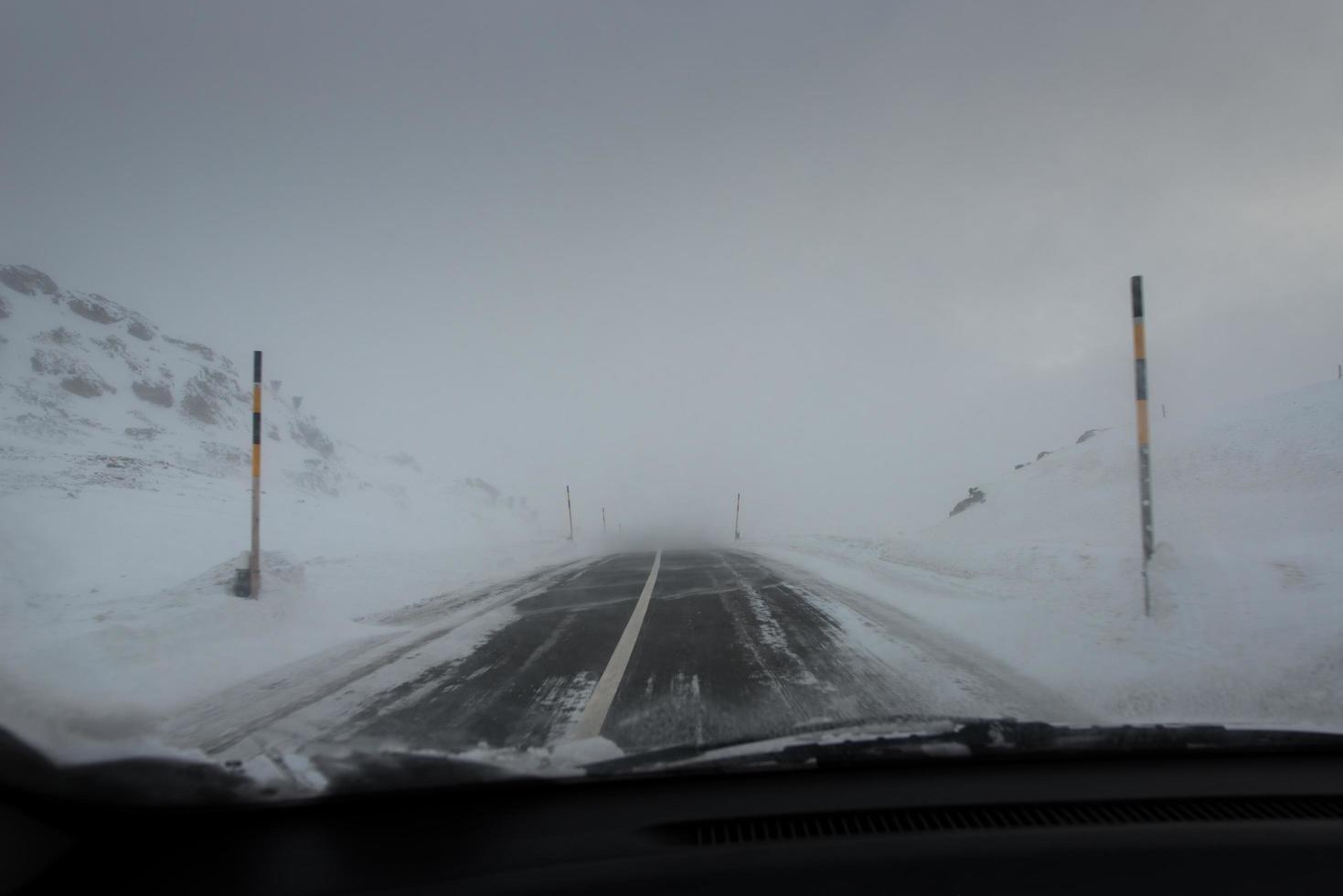guida su strada di montagna con tempesta di neve foto