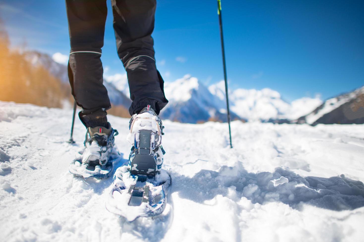 passeggiata con le ciaspole sulla neve durante le vacanze in montagna foto