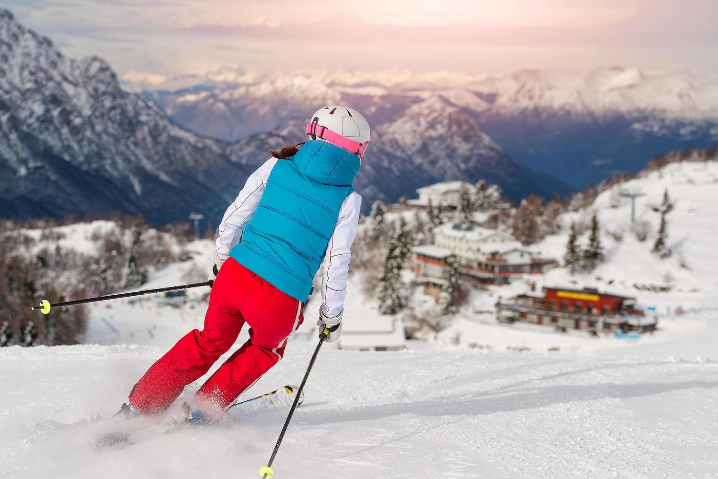 ragazza sportiva che scia verso il rifugio alpino foto