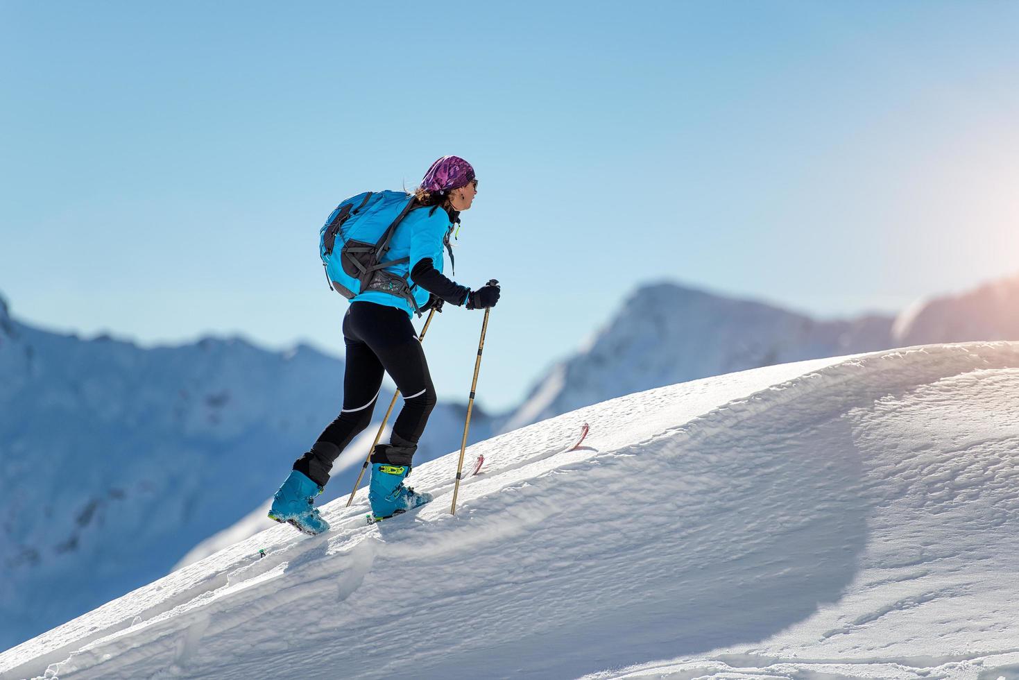 ragazza in salita con pelli di foca e sci alpinismo foto