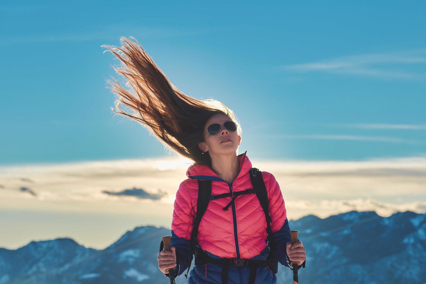 ragazza sportiva con i capelli al vento durante l'escursione in montagna foto
