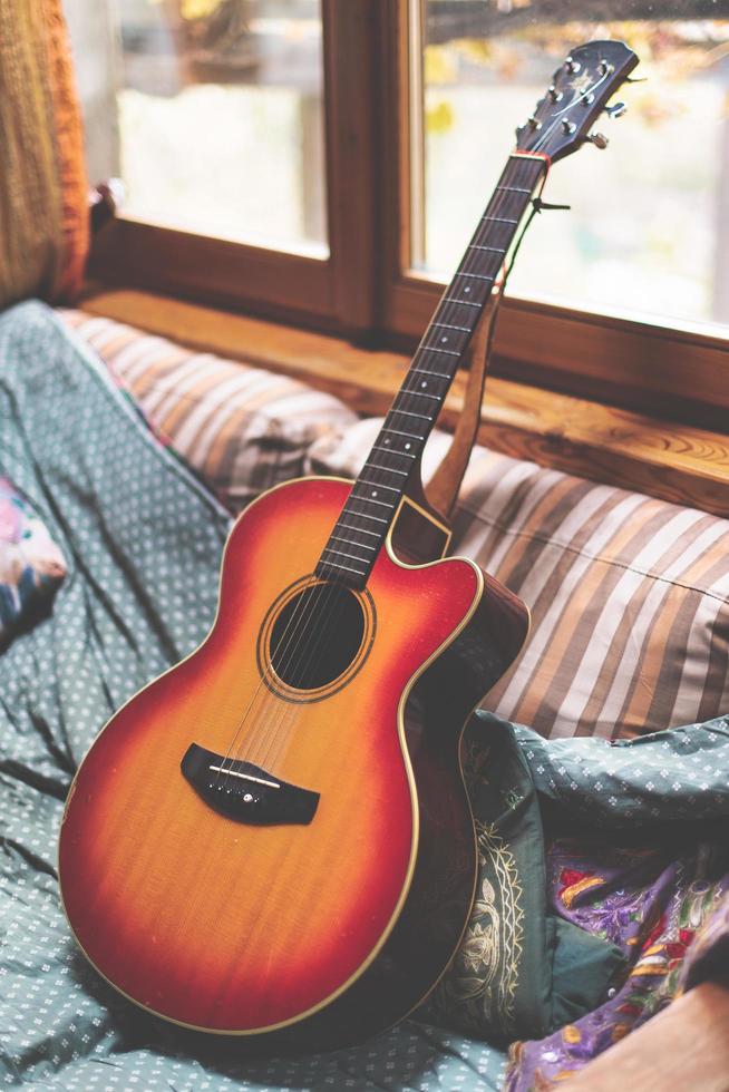 chitarra acustica appoggiata su un divano foto