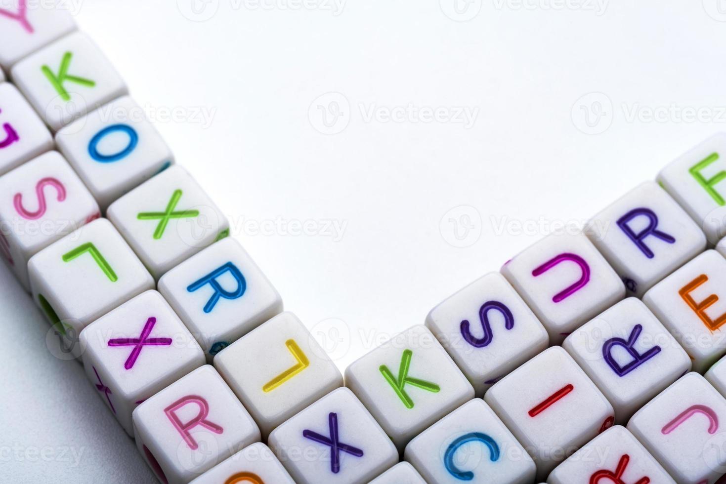 molti cubi decorativi colorati con lettere su sfondo bianco. foto