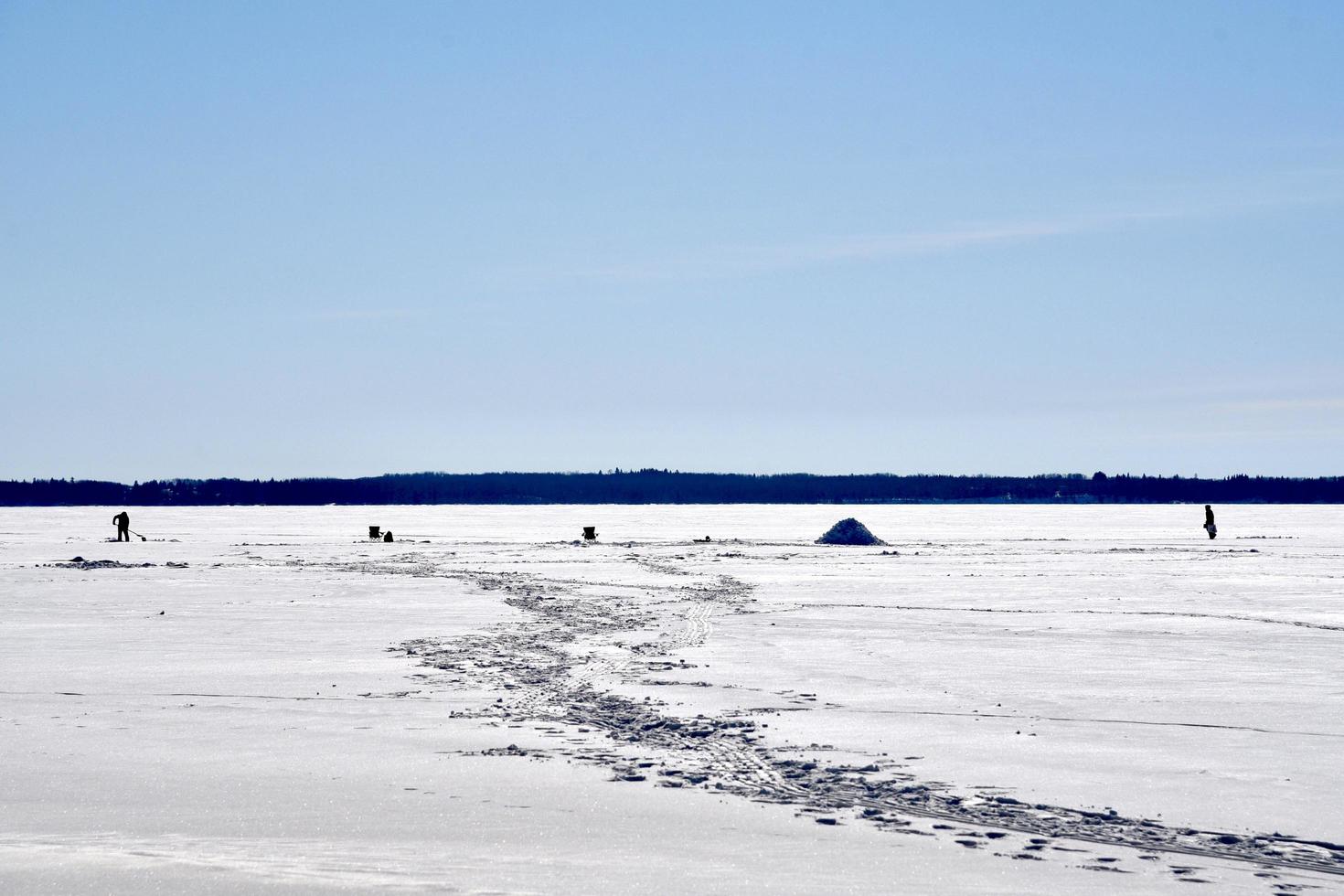 inverno a manitoba - pesca sul ghiaccio su un lago ghiacciato foto