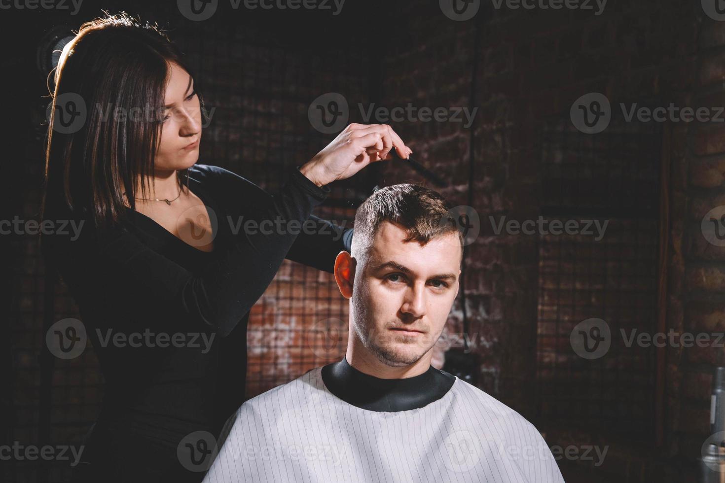 bella donna parrucchiere che taglia i capelli del cliente con le forbici in un negozio di barbiere. concetto di pubblicità e parrucchiere foto