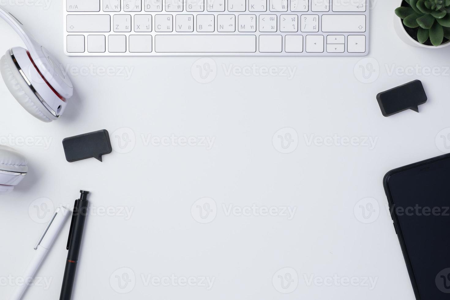 scrivania con vista dall'alto con cuffia tastiera e telefono cellulare su sfondo bianco tavolo foto