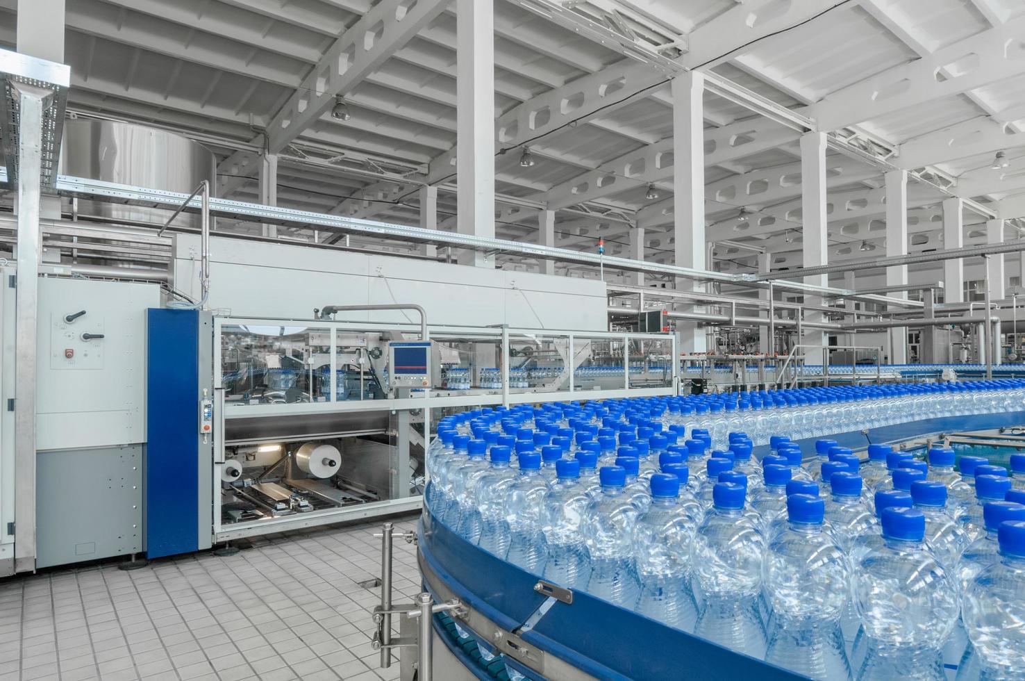tashkent, uzbekistan - 7 giugno 2016 - stabilimento per la produzione di bottiglie di plastica. bottiglie di plastica su un nastro trasportatore. riempimento di acqua in bottiglia foto