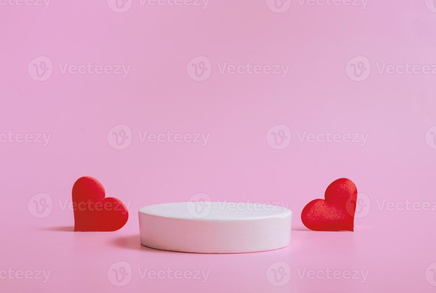 sfondo di san valentino con podi per prodotti o cosmetici con cuori su sfondo rosa. avvicinamento. foto
