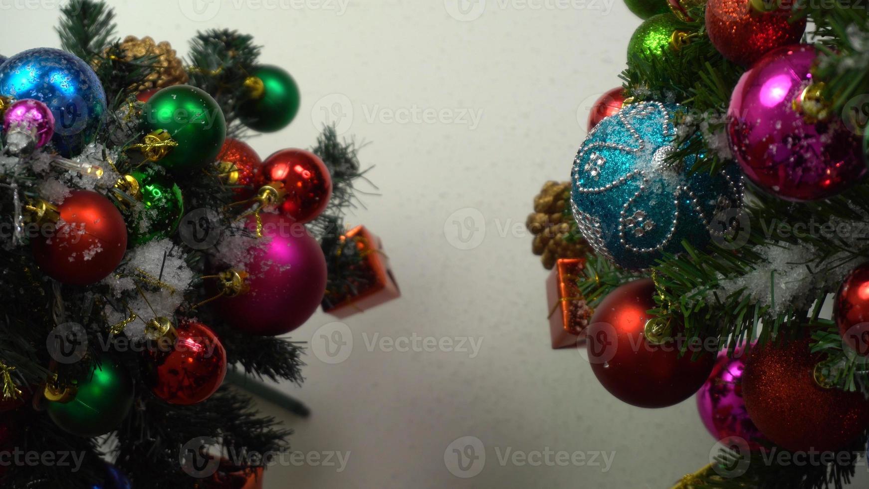 concetto di stagione dei saluti. Impostazione a mano di ornamenti su un albero di natale con luce decorativa foto
