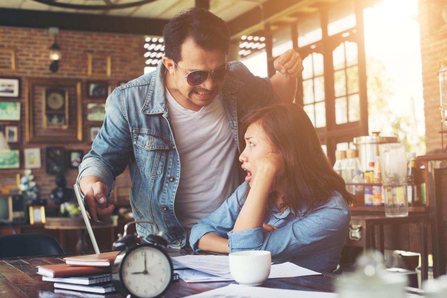 capo che grida a un dipendente stressato quando lavora con il laptop in ufficio, parlando di non essere completato dal lavoro, concetto di fallimento aziendale. foto