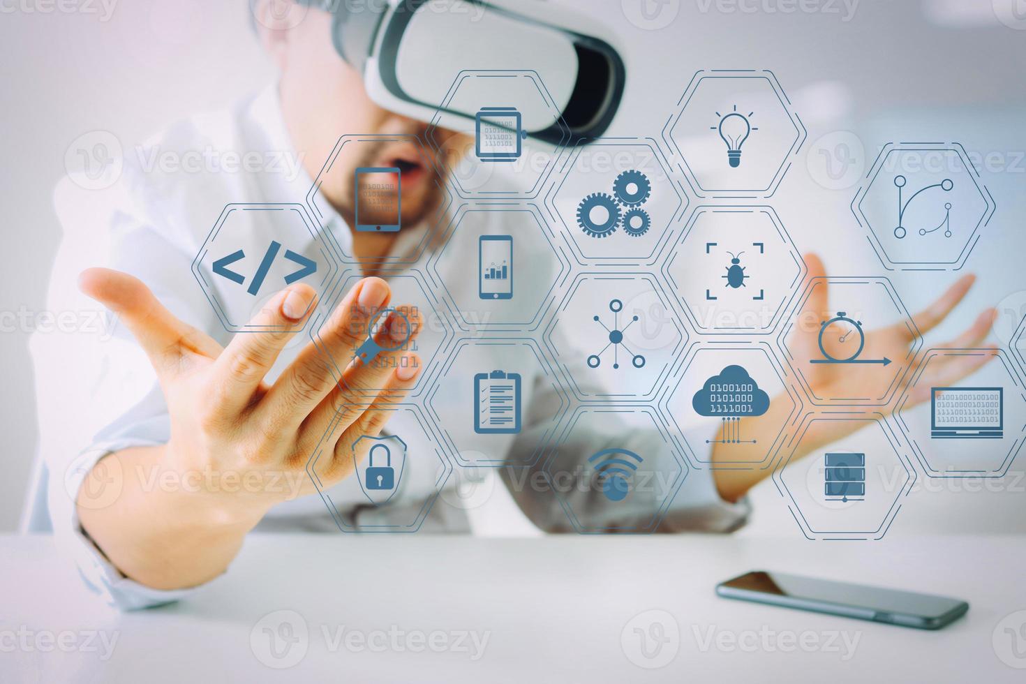 uomo d'affari che indossa occhiali per realtà virtuale in un ufficio moderno con telefono cellulare utilizzando con auricolare vr foto