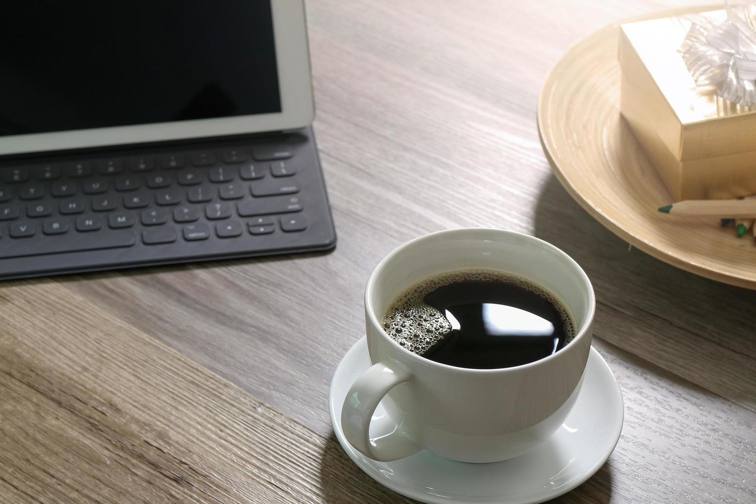 tazza da caffè e tastiera digitale docking station per tavolo, scatola regalo dorata e vassoio rotondo in legno, matita colorata su tavolo in legno, effetto filtro foto