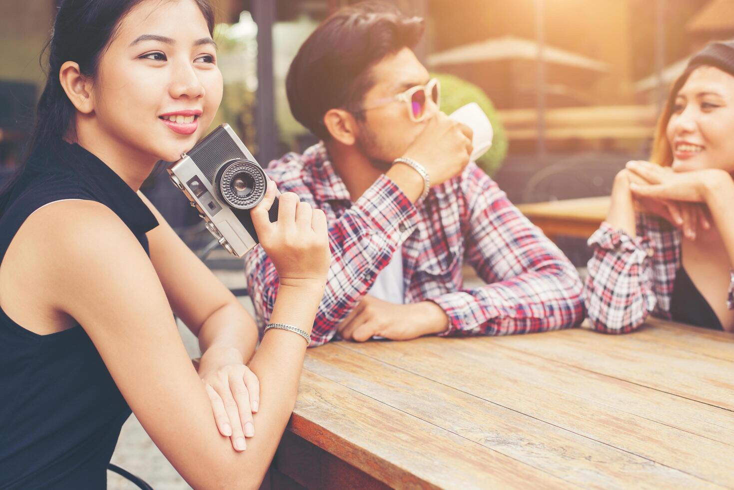 gruppo di giovani hipster seduti in un caffè, giovani amici allegri che si divertono mentre si prendono del tempo insieme, goditi la libertà delle vacanze. foto