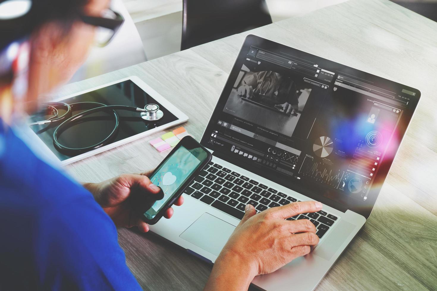 medico che lavora con tablet digitale e computer portatile nell'ufficio dell'area di lavoro medica e videoconferenza come concetto foto