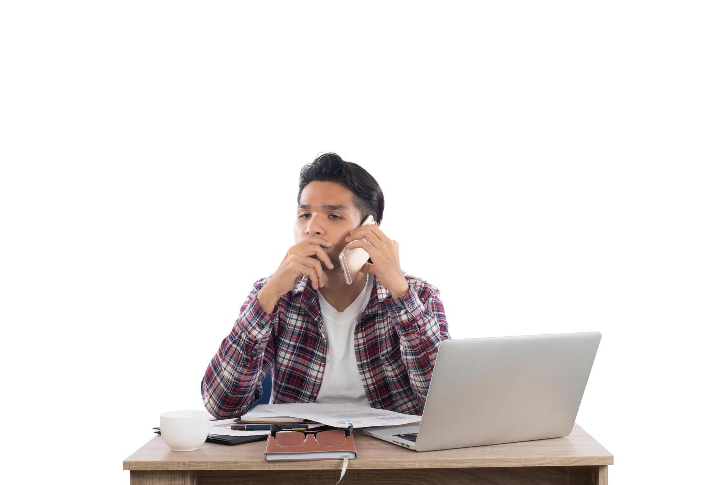 uomo d'affari che parla al telefono mentre lavora con il computer portatile in ufficio isolato su priorità bassa bianca. foto