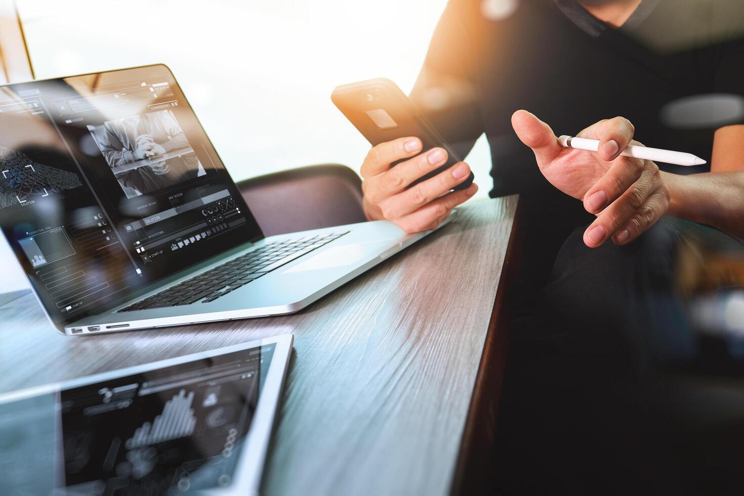 mano dell'uomo d'affari che partecipa alla videoconferenza con un computer portatile e un tablet alla scrivania in ufficio foto