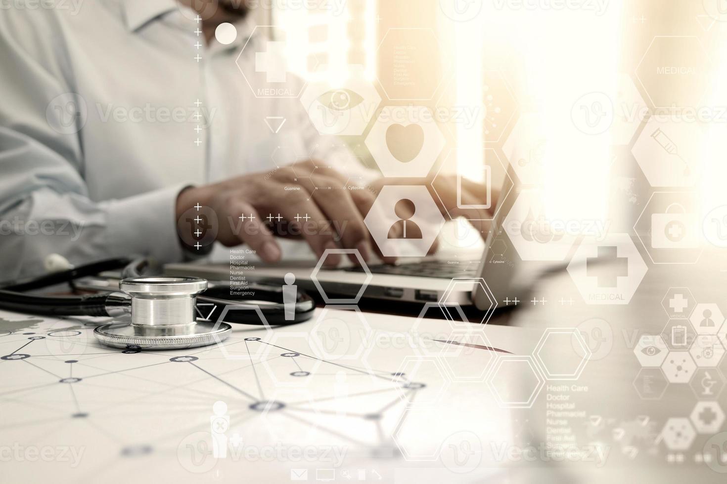 medico che lavora con il computer portatile nell'ufficio dell'area di lavoro medica e il diagramma multimediale della rete medica come concetto foto