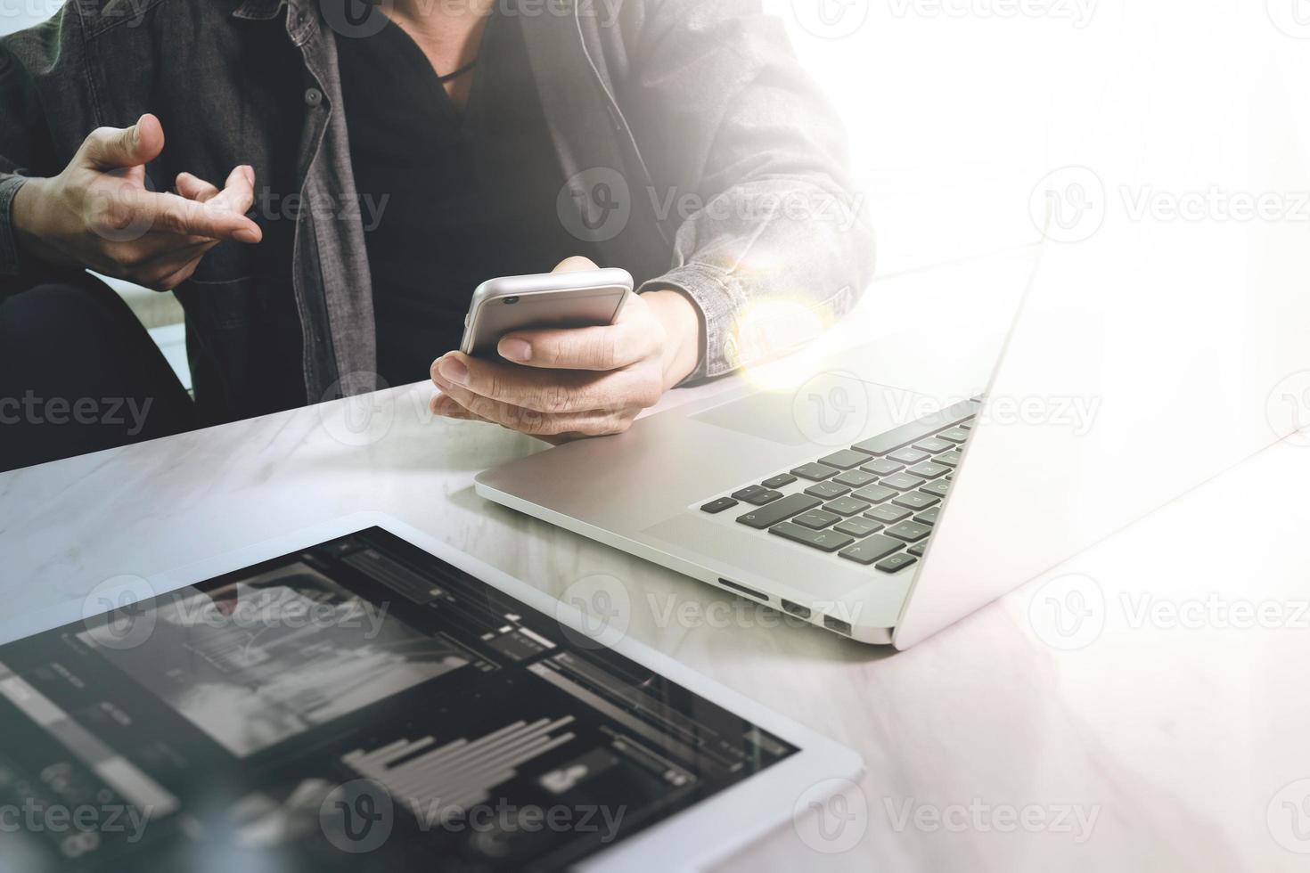 designer di siti Web che lavora su tablet digitale e computer portatile con smartphone e diagramma di progettazione grafica su scrivania in marmo come concetto foto