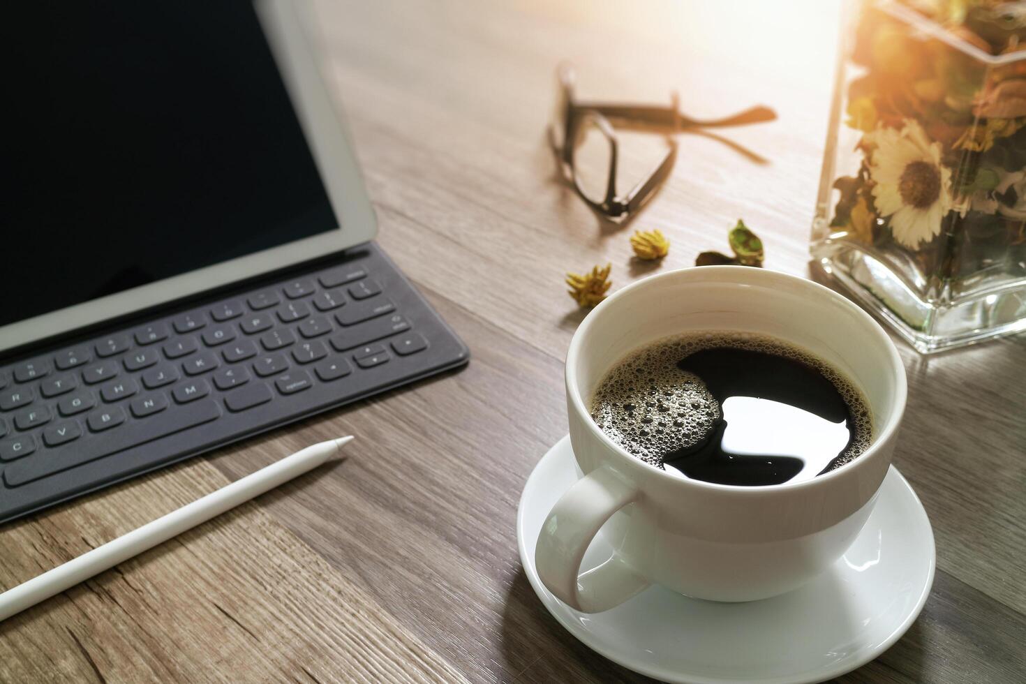 tazza di caffè e tastiera digitale dock da tavolo intelligente, vaso di erbe aromatiche, penna stilo sul tavolo di legno, effetto filtro foto