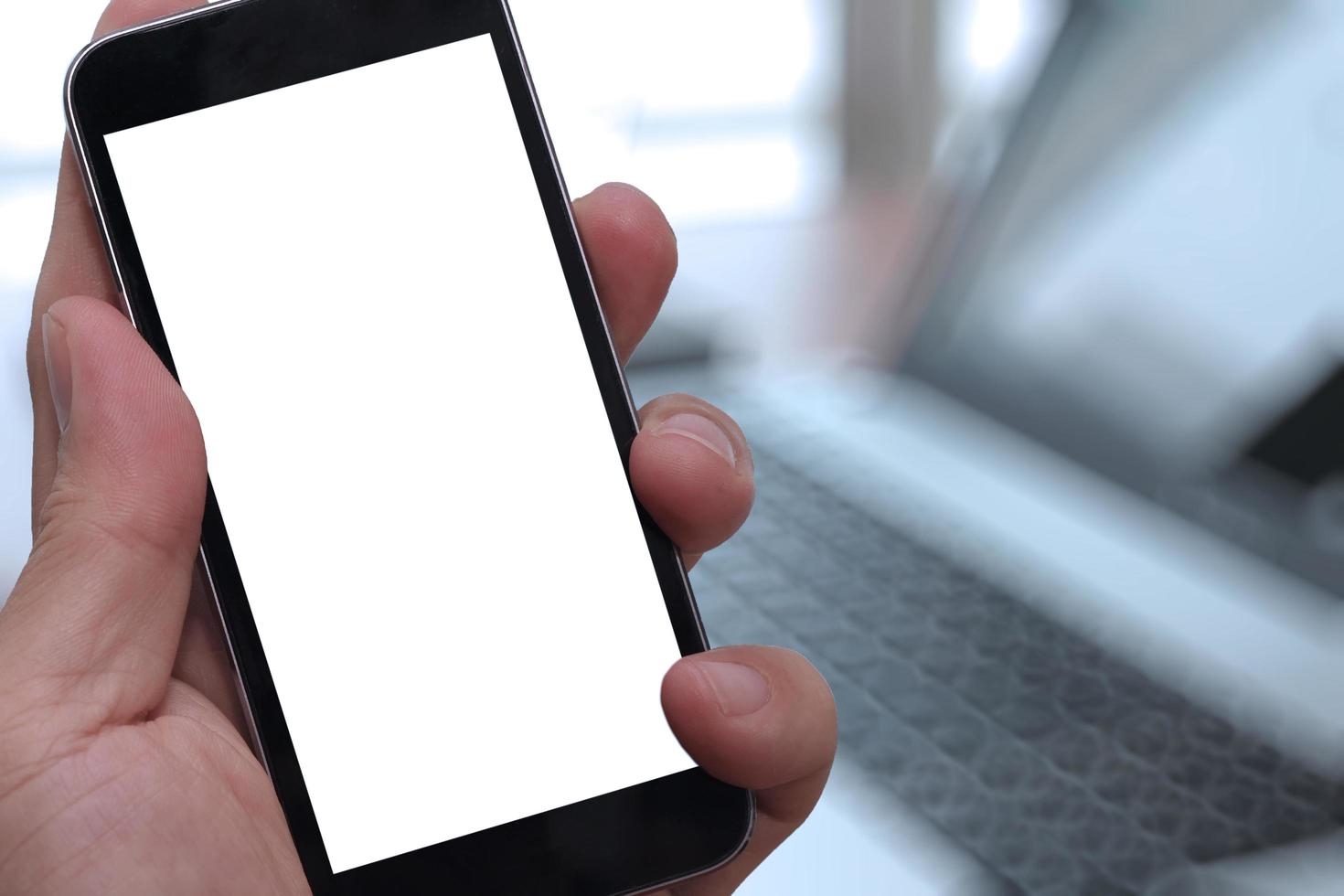 primo piano della mano che tiene lo schermo in bianco dello Smart Phone con fondo vago come concetto foto