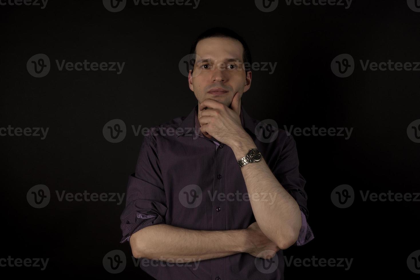un uomo con una camicia cremisi su sfondo nero. foto