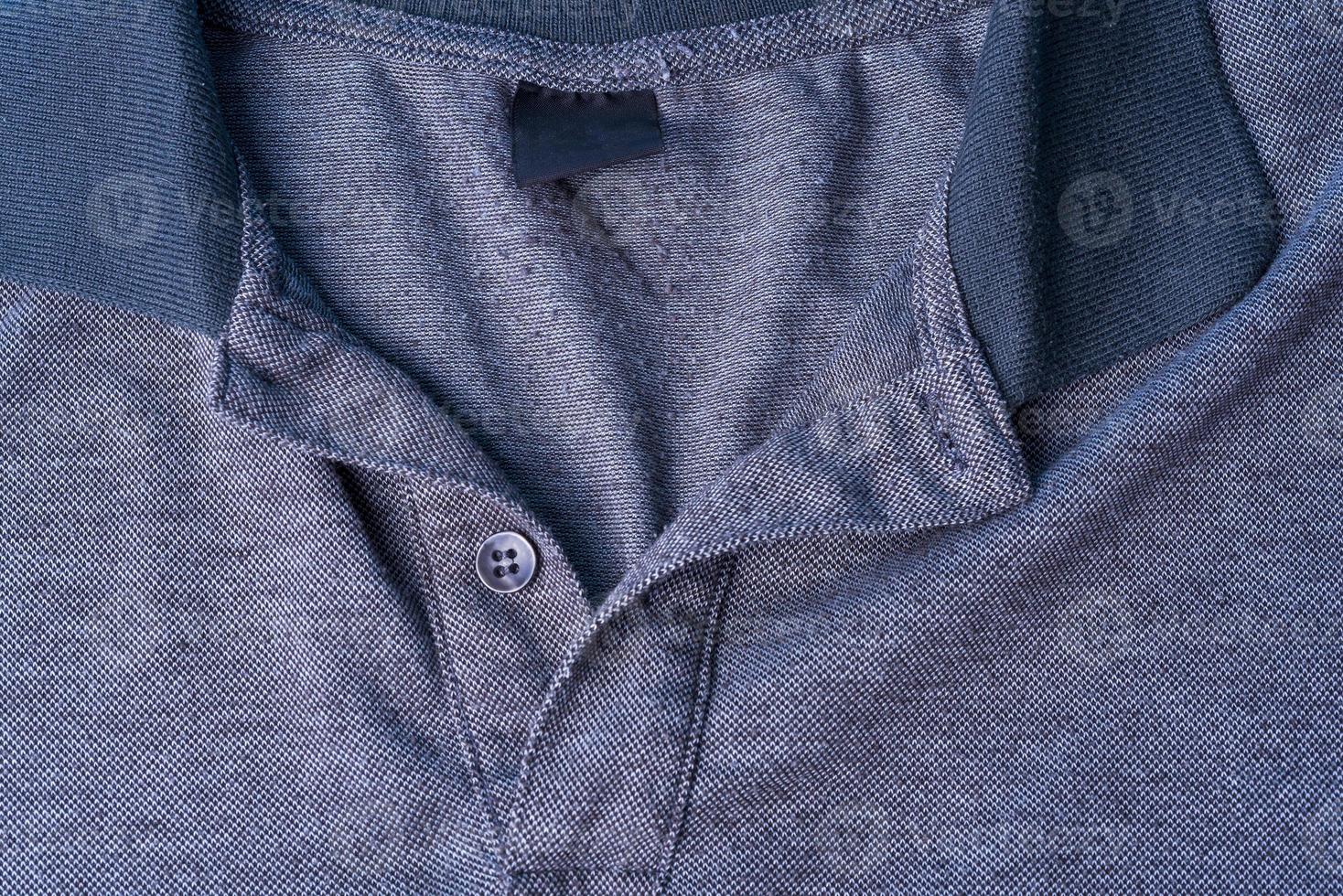 una polo grigio scuro con colletto in cotone e bottoni grigi. foto