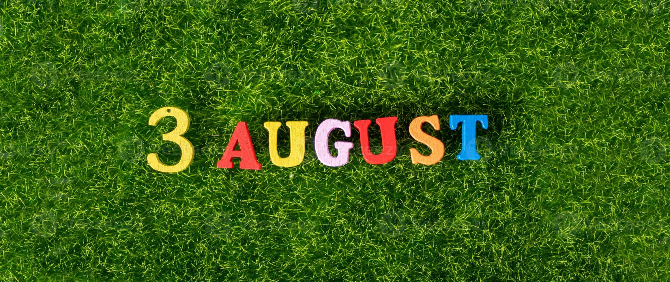 3 agosto immagine di lettere e numeri colorati in legno il 3 agosto sullo sfondo di un prato verde. un giorno d'estate. foto