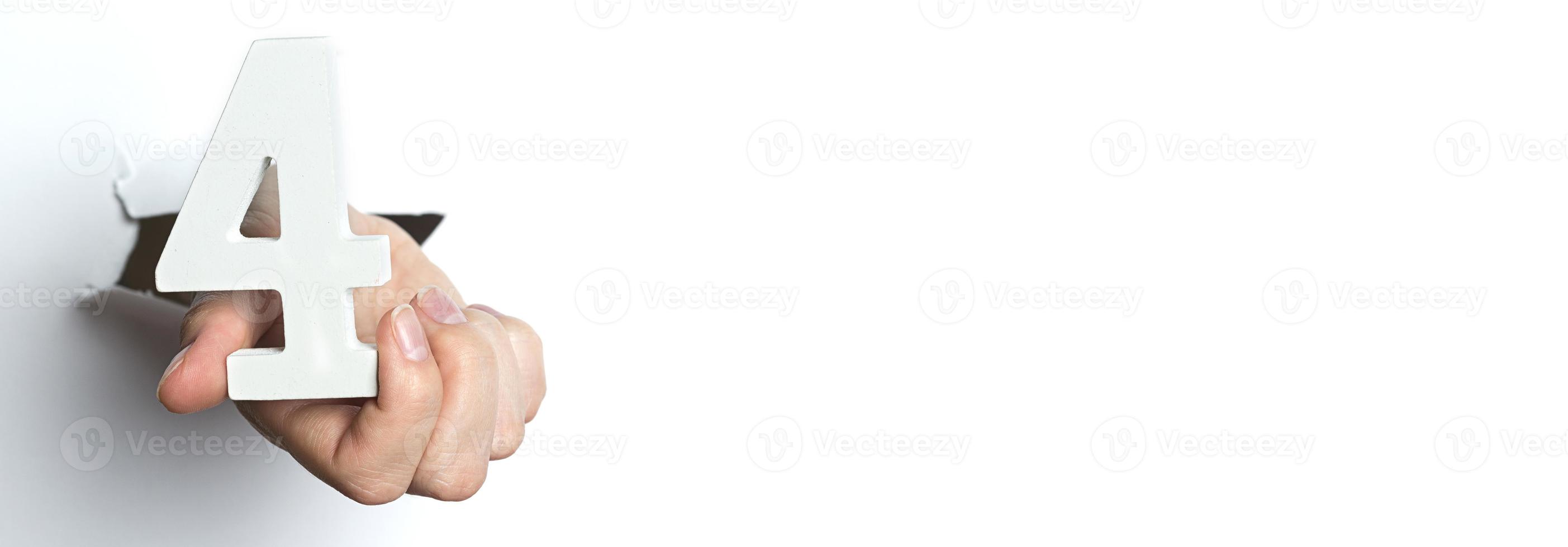 mano femminile che tiene uno sfondo bianco a quattro cifre. copia spazio. foto