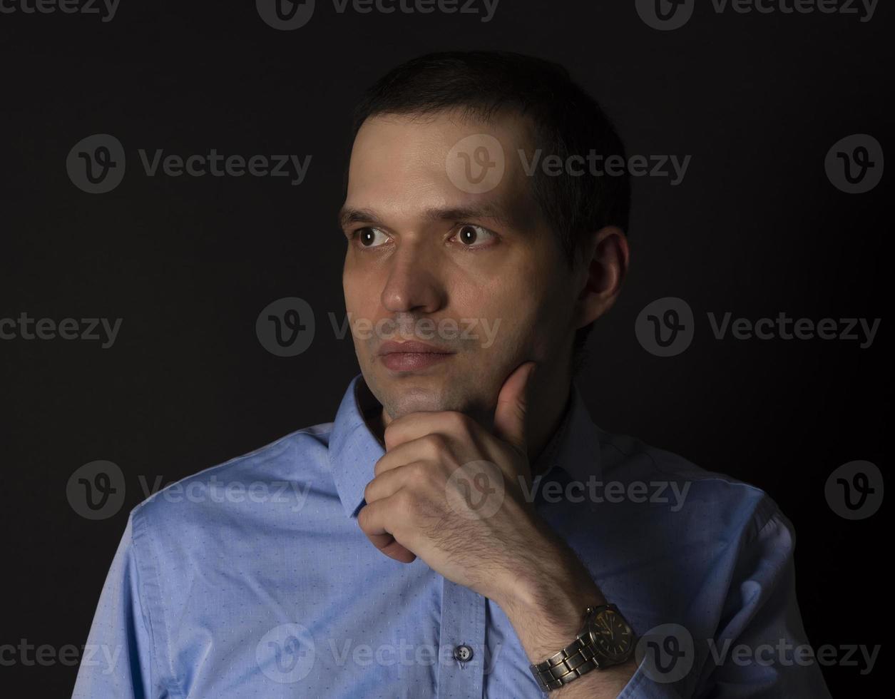 un uomo con una camicia blu su sfondo nero. foto