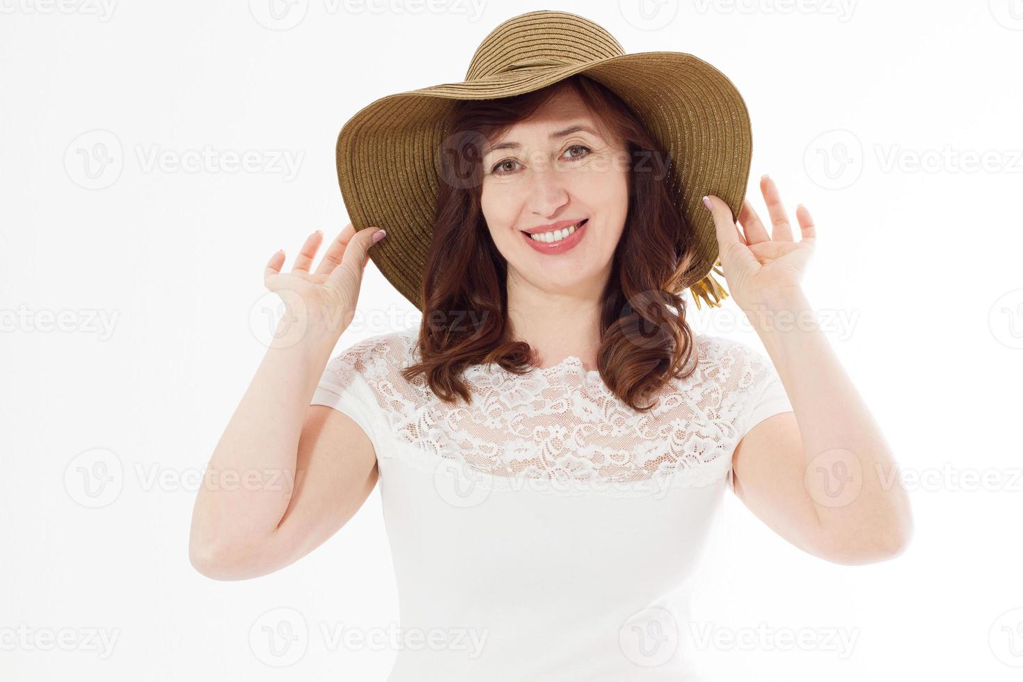 felice donna di mezza età in cappello estivo isolato su sfondo bianco con spazio di copia. accessorio estivo per la protezione della pelle dalle rughe del viso. felice menopausa. tempo caldo e vacanze. foto