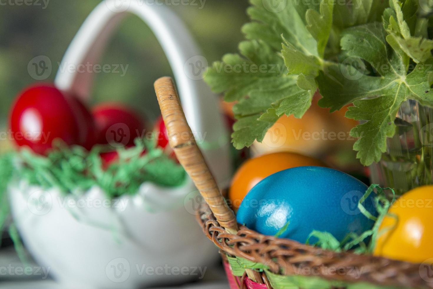 tavola di Pasqua con uova colorate di rosso, pane, rami verdi decorati, su tavola di legno bianco tavolato con tovaglia in tessuto. foto