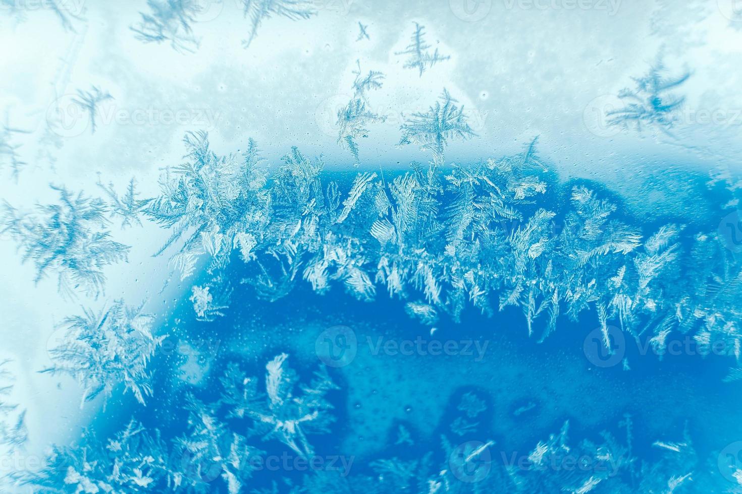 motivi di ghiaccio su vetro congelato. motivo di ghiaccio astratto sul vetro invernale come immagine di sfondo foto