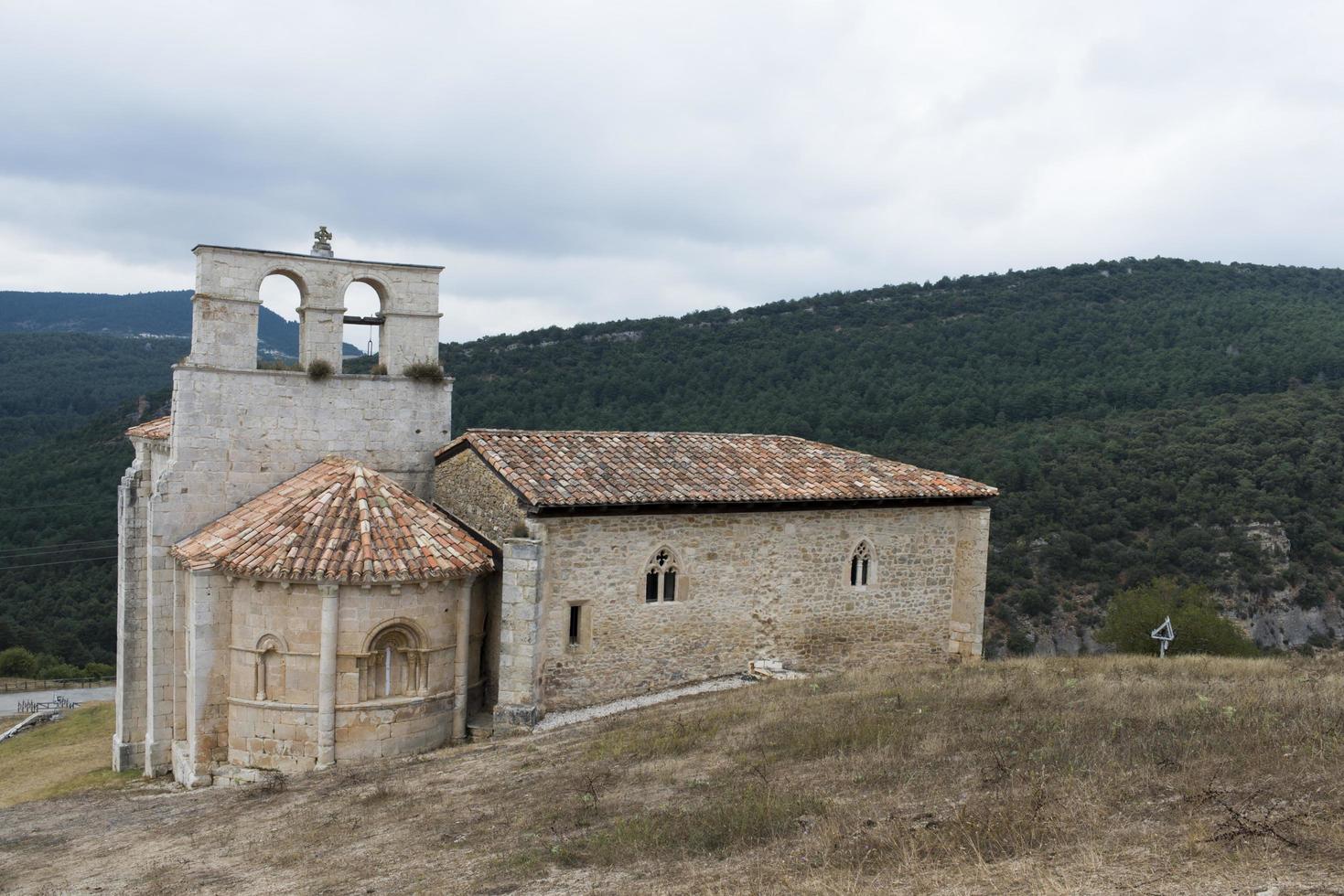 bella vista della chiesa dedicata a san pantaleon de losa e delle verdi colline alle spalle. burgos, merindades, spagna foto